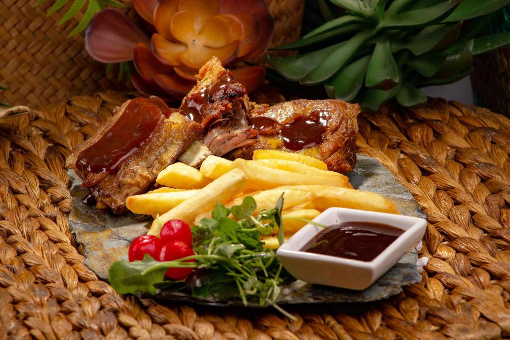 Costillas BBQ con papas fritas y salsa en plato de piedra