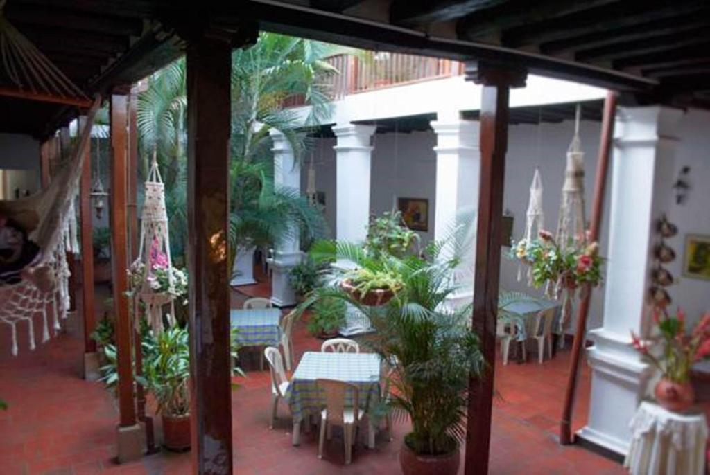 Patio interior del hotel con hamaca, columnas blancas y plantas tropicales