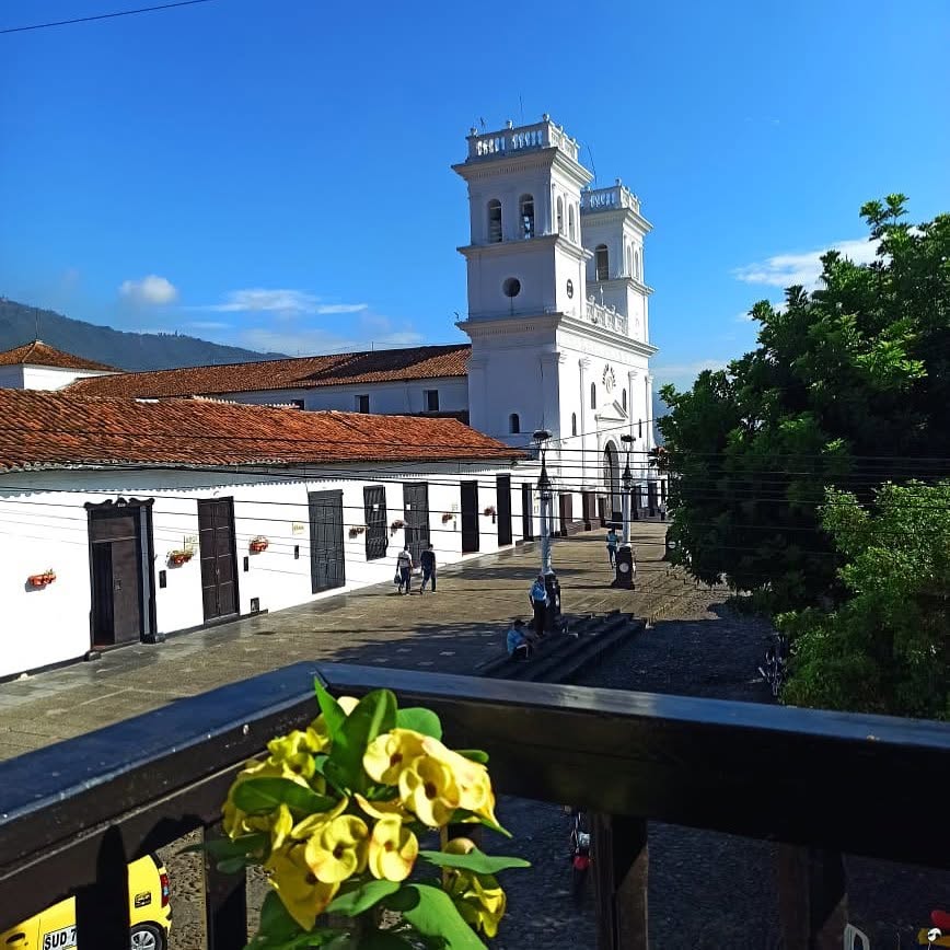 Vista de la Basílica Menor de Girón desde un balcón con flores amarillas